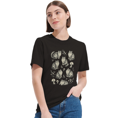 Närbild på kvinna i svart t-shirt med konstnärligt kattmotiv och naturdetaljer