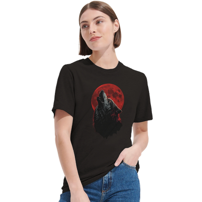 Kvinna bär svart t-shirt med ylande varg och blodmåne-motiv, stående med handen i fickan – Tecknad t-shirt